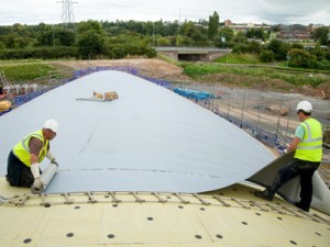 Single Ply Roofing Membrane being Laid over a curved roof